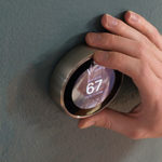 A hand using a smart thermostat correctly in order to avoid air conditioner repair in Bay Head